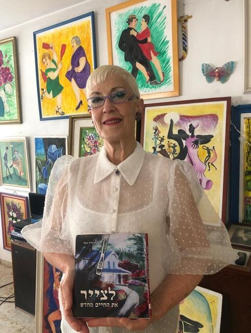 פייר-גבאי עם ספרה החדש על רקע הציורים של הוריה 